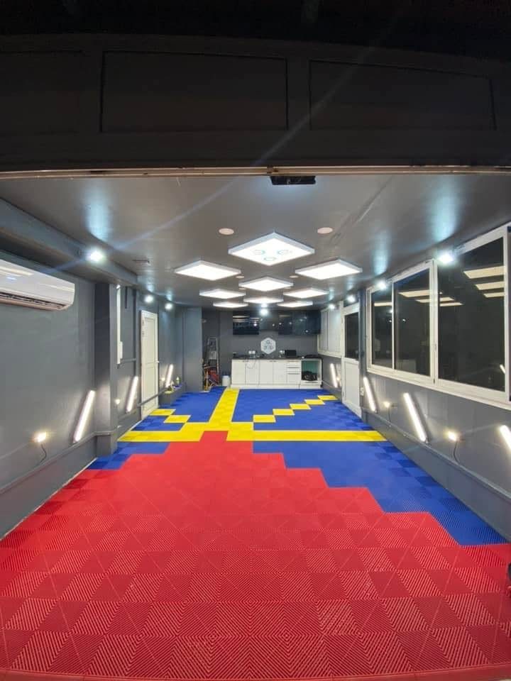 Atelier G Car Care : sol en dalles rouges, jaunes et bleues, éclairage LED