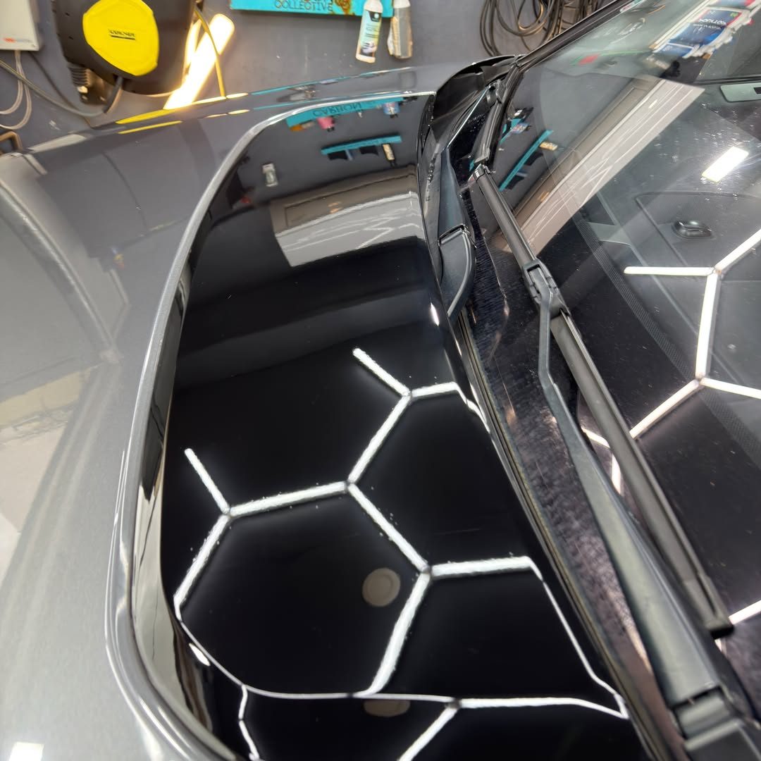 Capot et pare-brise reflétant les néons hexagonaux