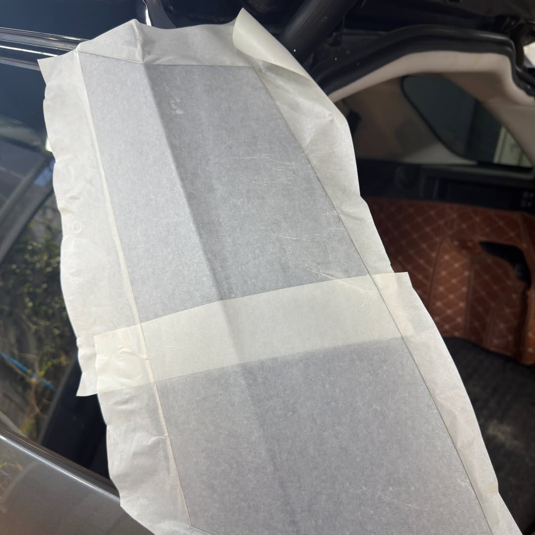 Film de protection en cours de découpe sur une portière
